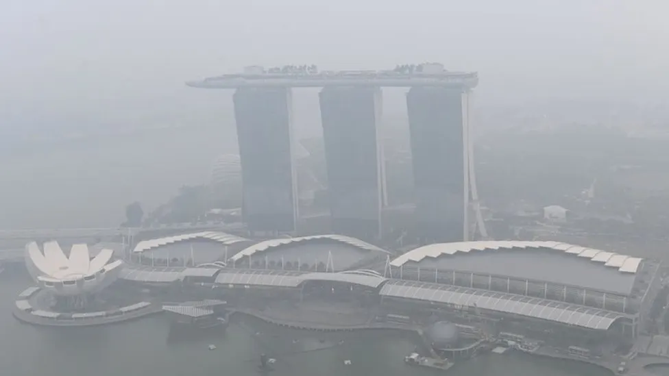 Singapore Flyer dan gedung-gedung komersial diselimuti kabut asap di kawasan Marina Bay, Singapura.